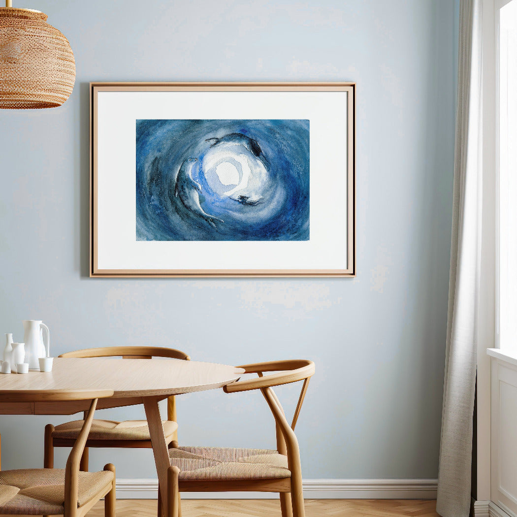 Framed art piece depicting the transformation of a selkie from seal to woman on a wall above a dining table with chairs.